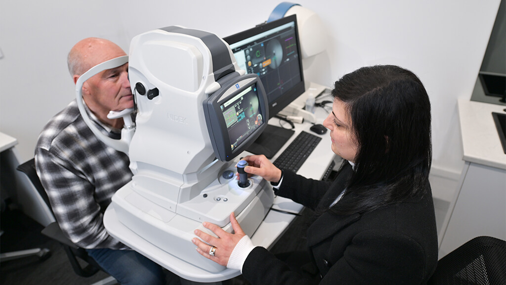 Gentleman gets an eye examination with advanced optometry equipment at Eyes In Essendon, a boutique optometrist in Melbourne