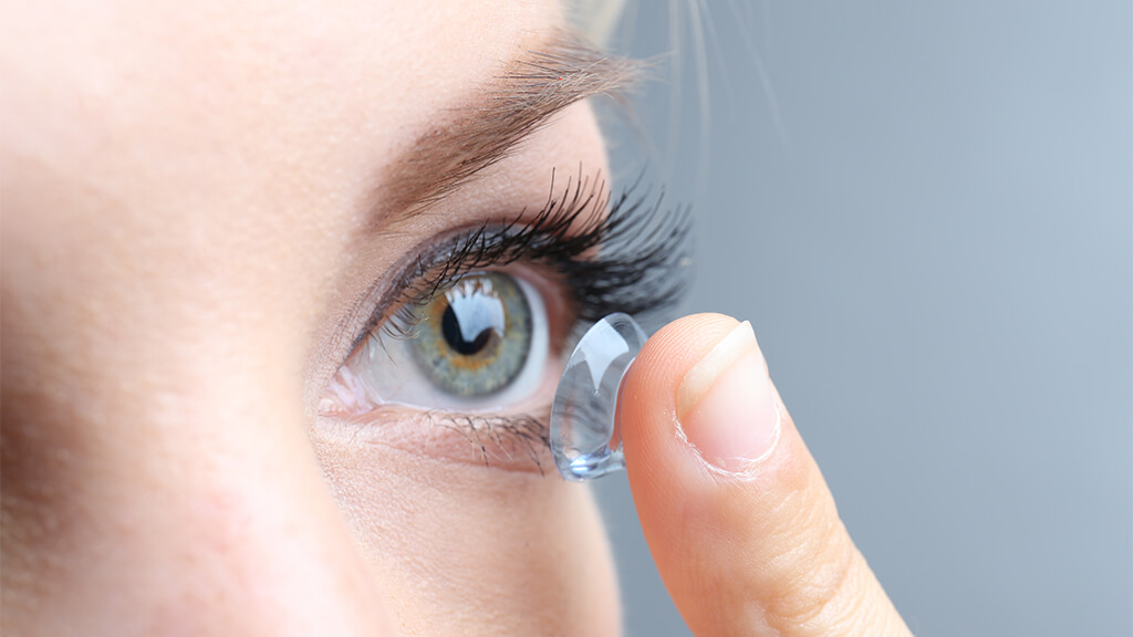 Close up of contact lens fitting to eye