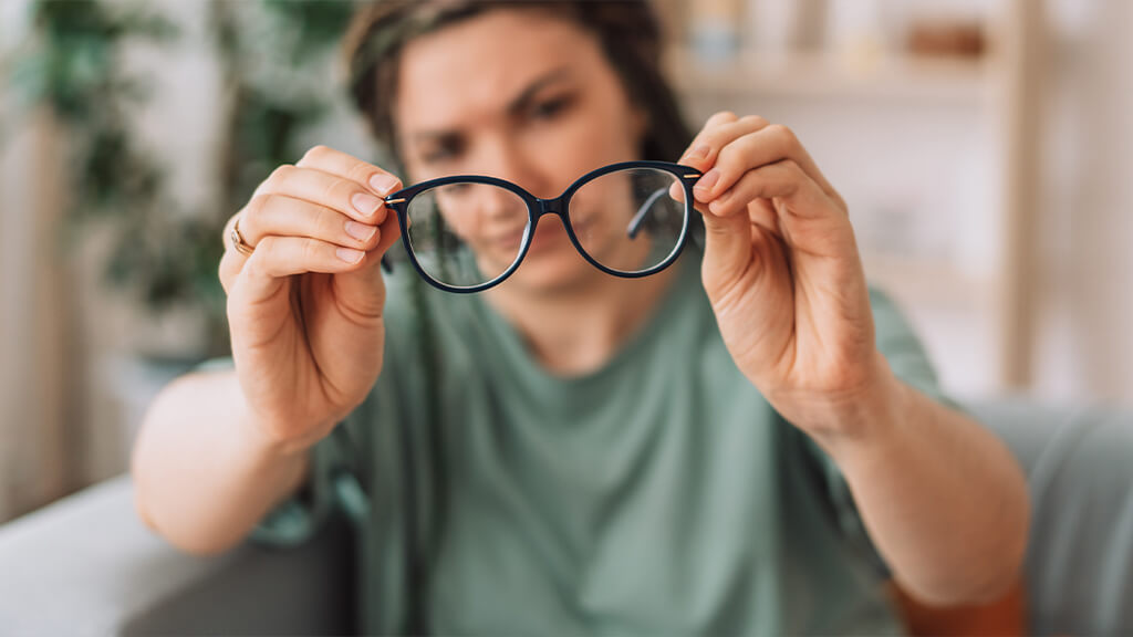 Woman holds glasses in front of her